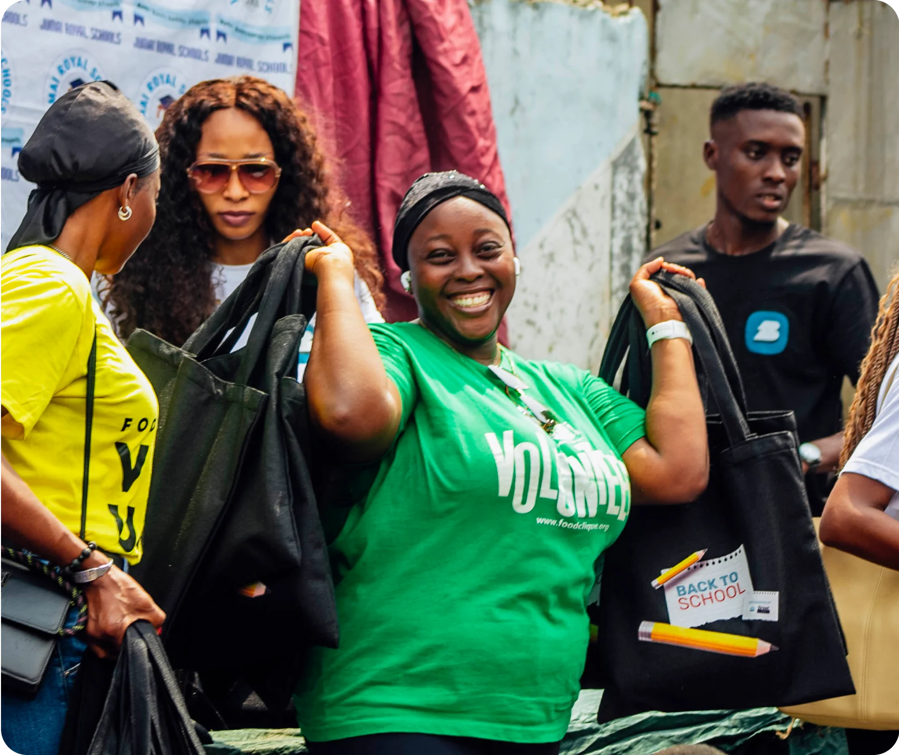 a smiling woman in green smiling with a handful of bags